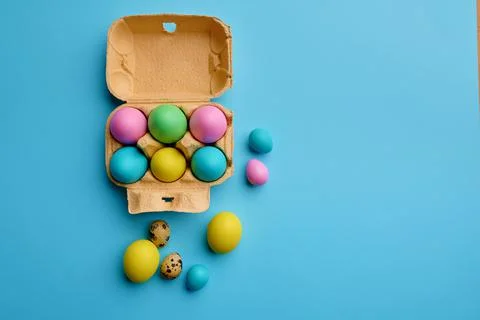 Colorful easter eggs in box on blue background Stock Photos