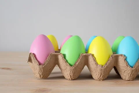 Colorful Easter eggs in box on the table with copy space. Stock Photos