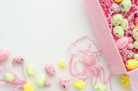 Colorful Easter eggs in a box on white table, top view. Easter mock up flat lay Stock Photos