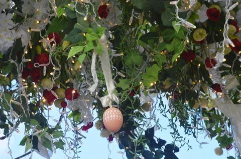 Colorful Easter eggs on the branches of a decorative tree near a church. Fest Stock Photos