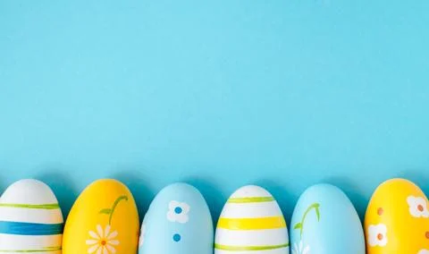 Colorful easter eggs on bright blue background banner. Stock Photos