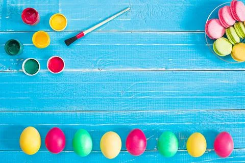 Colorful easter eggs, brush and paint on wooden board background with space. Stockfoto's