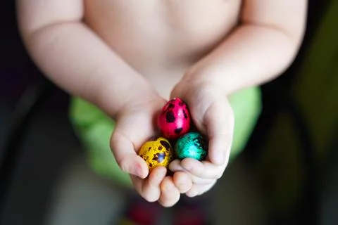 Colorful easter eggs in child hands after egg-hunt Stock Photos