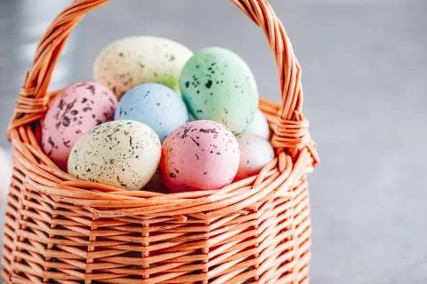 Colorful Easter eggs closeup in the basket on gray stone concrete background Stock Photos