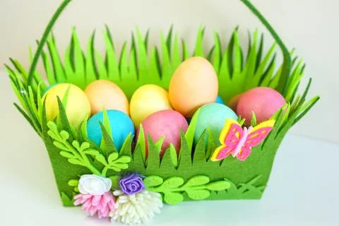 Colorful Easter Eggs in a Decorative Felt Basket Stock Photos