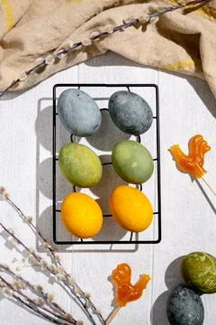 Colorful easter eggs drying on a black metal rack, accompanied by pussy wil.. Stock Photos