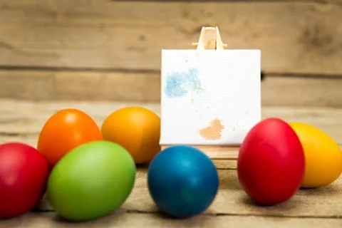 Colorful easter eggs with empty canvas for own text, blobs on it, wooden backgro Stock Photos