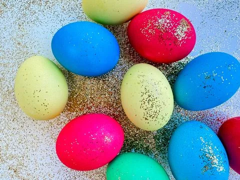Colorful Easter eggs with glitter on a sparkling background, festive holiday Stock Photos