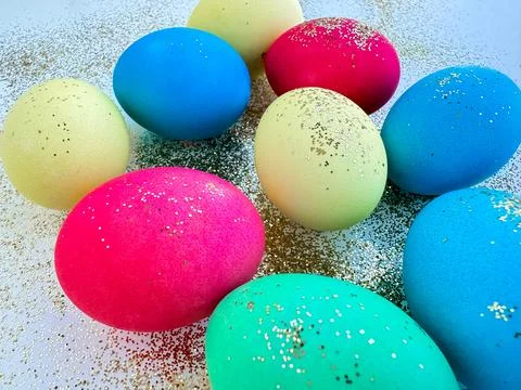 Colorful Easter eggs with glitter on a sparkling background, festive holiday Stock Photos