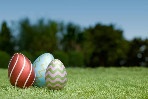 Colorful Easter eggs on green grass under a clear blue sky Stock-Illustration