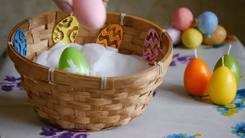 Colorful Easter Eggs green, yellow and pink In A Basket. Male hand adds one pink Stock-Footage 106146849