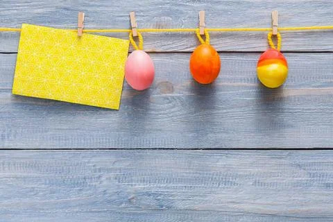 Colorful easter eggs hanging on a clothesline outdoors Stock Photos