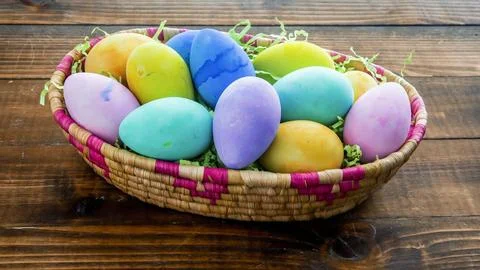 Colorful Easter eggs inside bucket on wooden table Stock Photos