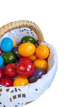 Colorful Easter eggs inside straw wicker against white background Photos