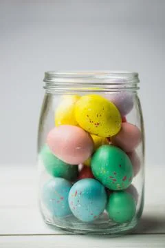 Colorful Easter eggs in jar on table Stock Photos