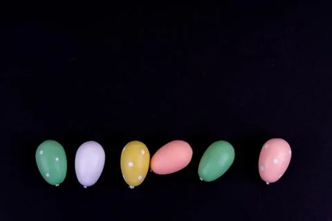 Colorful easter eggs laying in a row on black background Stock Photos