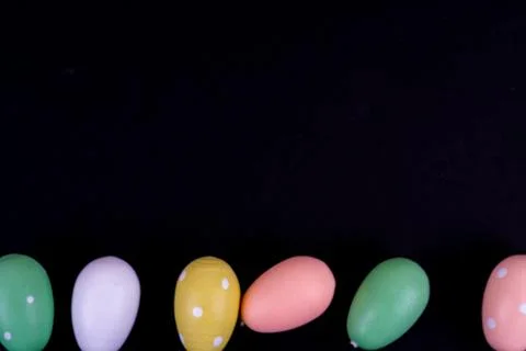 Colorful easter eggs laying in a row on black background Stock Photos