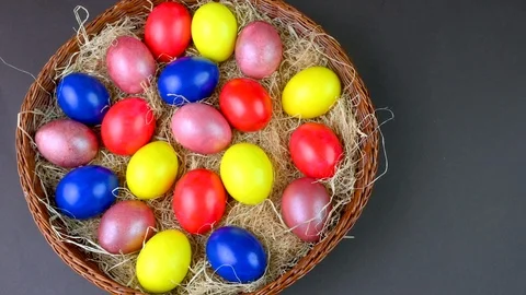 Colorful easter eggs lie on a bacon in a basket on a gray background. Stock Footage 125617595