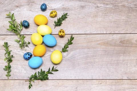 Colorful easter eggs lie in decor yellow bucket on wooden background with gre Foto stock
