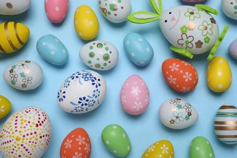 Colorful Easter eggs on light blue background, flat lay Stock Photos