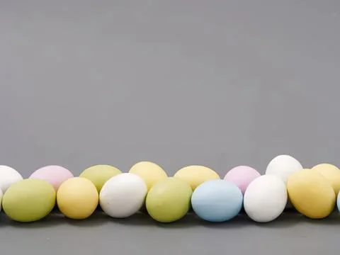 Colorful easter eggs lined up on dark gray surface Stock Photos