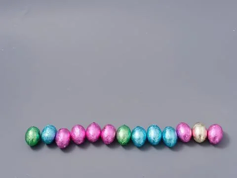 Colorful easter eggs lined up on gray background Stock Photos