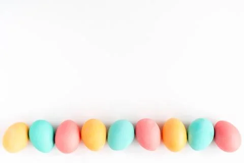 Colorful Easter eggs lined on white background. Flat lay. Stock Photos