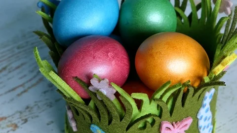 Colorful Easter Eggs Lying In A Grass Basket Whit Easter Rabbits On A Wooden Bac 스톡 동영상 126589086