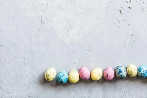 Colorful easter eggs lying on gray concrete background. Flat lay. Top view. H Stock Photos