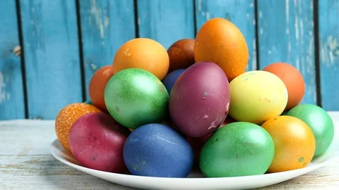 Colorful Easter Eggs Lying On White Plate On A Blue Wooden Background Panning Sl Stock Footage 126575626