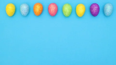 Colorful Easter eggs move in circle on top of blue background - Stop motion Stock Footage 124357874