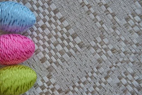 Colorful easter eggs on a natural patterned linen tablecloth Stock Photos