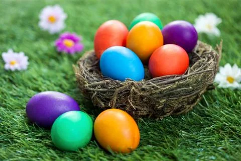 Colorful Easter eggs in the nest on the grass Stock Photos