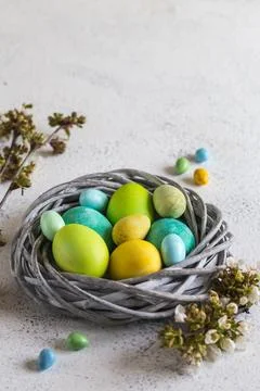 Colorful easter eggs in a nest on a light background Stock Photos