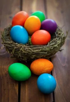 Colorful Easter eggs in the nest on the old wooden background  Stock Photos
