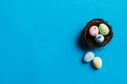 Colorful easter eggs in nest on table background with copy space top view 스톡 사진