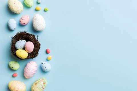 Colorful easter eggs in nest on table background with copy space top view 库存照片
