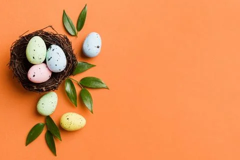 Colorful easter eggs in nest on table background with copy space top view 库存照片