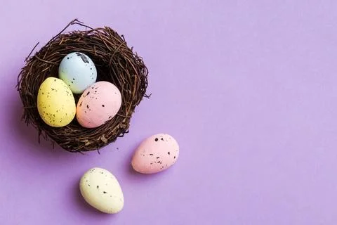 Colorful easter eggs in nest on table background with copy space top view 库存照片