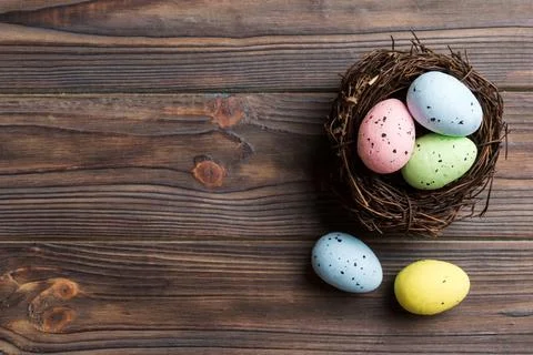 Colorful easter eggs in nest on table background with copy space top view 스톡 사진