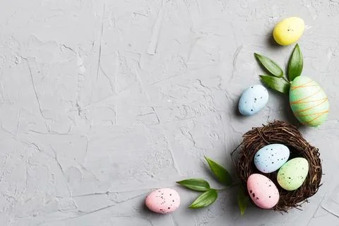 Colorful easter eggs in nest on table background with copy space top view 库存照片