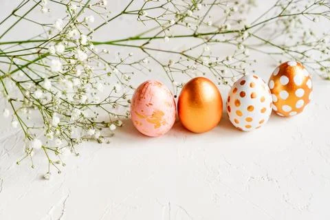 Colorful easter eggs painted in gold, white and pink colors on white backgr.. Stock Photos