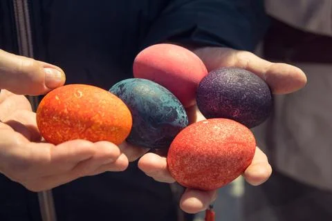 Colorful easter eggs in person's hands, close-up Stock Photos