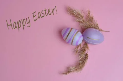 Colorful Easter eggs on a pink background. Happy Easter text. Stock Photos