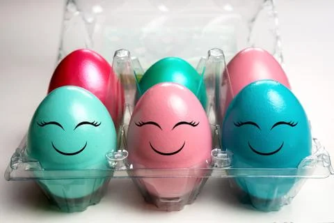 Colorful easter eggs in plastic egg case pack with happy emoji faces Stock Photos