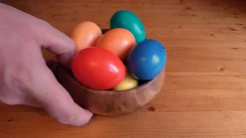 Colorful easter eggs is put on the table. One egg added later Stock Footage 74576945