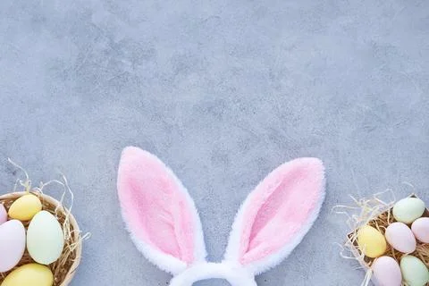 Colorful Easter eggs with rabbit ears on yellow background. Stock Photos
