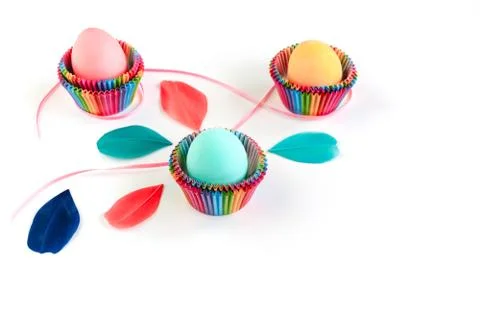 Colorful Easter eggs in raibow colored paper forms for cupcakes on white Stock Photos
