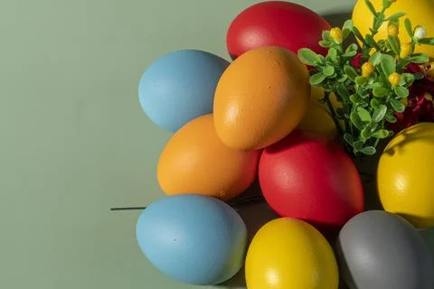 Colorful Easter eggs in red, blue, orange, and yellow arranged with spring .. Stock Photos