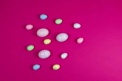 Colorful Easter eggs on a red raspberry background with copy space. Flat lay Stock Photos